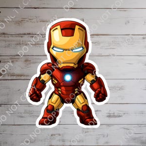 K&ouml;nnte beinhalten: Ein Aufkleber mit einer Cartoon-Figur von Iron Man. Die Figur steht in einer roten und goldenen R&uuml;stung mit einem leuchtenden blauen Lichtbogenreaktor und Augen. Der Aufkleber befindet sich auf einem hellen Holzmaserungshintergrund.