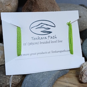 Puede incluir: Una l&iacute;nea de pesca trenzada verde empaquetada en una tarjeta blanca con el texto "Tenkara Path 12' (365cm) braided level line" y la direcci&oacute;n del sitio web "Tenkarapath.com".