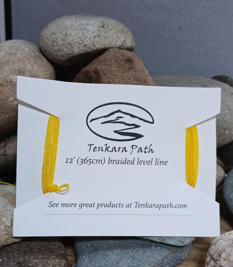 Puede incluir: Una tarjeta blanca con una l&iacute;nea de pesca trenzada amarilla. La tarjeta tiene el texto "Tenkara Path" y "12' (365cm) braided level line". La tarjeta tambi&eacute;n tiene un logotipo de una cordillera con un r&iacute;o que la atraviesa. El texto "See more great products at Tenkarapath.com" est&aacute; en la parte inferior de la tarjeta.