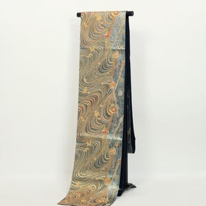 Può includere: Un set di tre tazze in ceramica con finitura opaca e macchiettata. Le tazze sono nei toni del crema, grigio chiaro e grigio scuro. Ogni tazza ha un design semplice e minimalista.