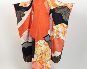 May include: A traditional Japanese kimono with a vibrant orange, black and white geometric pattern. The kimono features intricate details and a flowing silhouette.