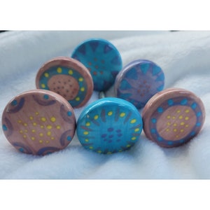 May include: Six ceramic knobs with a variety of colorful abstract designs. The knobs are round and have a metal screw on the back.