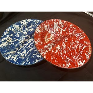 May include: Two enamelware serving platters. One is blue with white marbling, the other is red with white marbling. Both have a divided design and black rims. These platters are ideal for serving food.