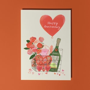 Buon anniversario / Cesto d'amore / Champagne, cioccolatini, fiori / Biglietto di auguri