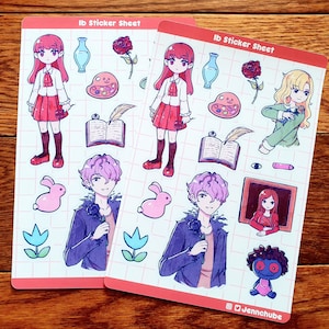 Può includere: Due fogli di adesivi con personaggi del videogioco "Ib". I fogli sono rosa e blu con un motivo a griglia. I personaggi sono una ragazza con i capelli rossi, un ragazzo con i capelli viola e una ragazza con i capelli biondi. Gli adesivi includono un libro, una rosa, una tavolozza di colori, un coniglio e un tulipano.