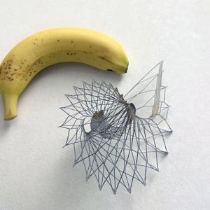 May include: A yellow banana with brown spots next to a black and white geometric design.