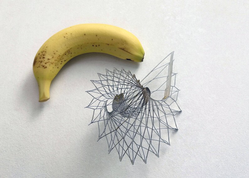 May include: A yellow banana with brown spots next to a black and white geometric design.