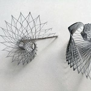 May include: Two black wire sculptures, one in a spiral shape and the other in a more abstract form.