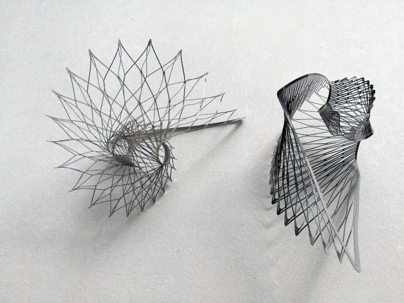 May include: Two black wire sculptures, one in a spiral shape and the other in a more abstract form.