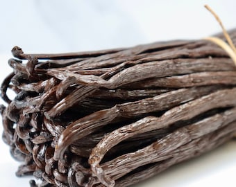 May include: A bundle of dried vanilla beans, tied together with twine. The beans are dark brown and have a glossy finish.