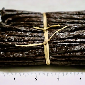 May include: A bundle of dried vanilla beans tied together with twine, measuring approximately 3 inches in length.