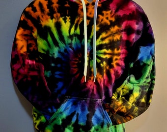 May include: A vibrant tie-dye hoodie in a spiral pattern, featuring a spectrum of colors including pink, orange, yellow, green, blue, and purple. The hoodie has a front pocket, a hood with a drawstring, and a black base color.