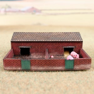 Op de afbeelding: Een miniatuur varkensstal van baksteen met een bruin dak. Er zijn drie roze varkens in de stal.