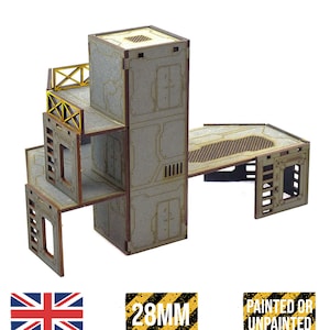 May include: A modular, unpainted MDF terrain set for tabletop gaming. The set features multiple levels, walkways, and industrial-style detailing. Includes the text "28MM SCALE" and "MADE IN THE UK".