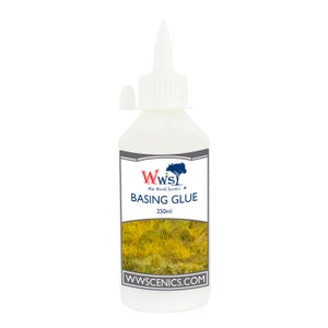 May include: A white plastic bottle of basing glue with a black label. The label has the text "WWS" in red and blue, "War World Scenics", and "BASING GLUE" in black. The bottle is 250ml and has a white cap with a small white nozzle. The label also has the website "wwscenics.com" in black.