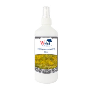 May include: A white spray bottle with a black label that says "WW Scenery" and "Layering Spray Adhesive 500ml". The label also has a website address: "www.scenics.com". The bottle is filled with a clear liquid and has a white spray nozzle.
