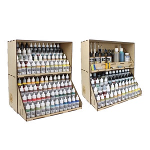 Può includere: Un rack di stoccaggio per vernice in legno con tre ripiani. Lo scaffale superiore contiene strumenti e bottiglie. Lo scaffale intermedio contiene piccole bottiglie di vernice. Lo scaffale inferiore contiene una grande collezione di bottiglie di vernice in vari colori.