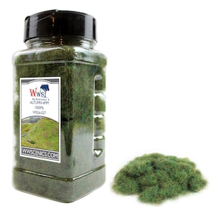 Peut inclure: Un pot en plastique transparent rempli d'herbe statique de couleur automnale de 6 mm, verte et brune. Le pot est étiqueté "WW Scenics Autumn 6mm 1000ml WSG6-027" et "wwscenics.com". Un tas de la même herbe est présenté dans le coin inférieur droit de l'image.