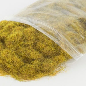 Może przedstawiać: Torebka z żółto-zieloną trawą statyczną do modelarstwa kolejowego lub innych projektów hobbystycznych.