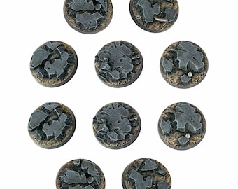 May include: Ten round, gray and brown, plastic bases with a cracked and weathered texture. The bases are designed for miniature wargaming.