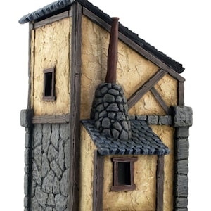 May include: A miniature stone and wood building with a brown roof and two chimneys. The building has a stone wall on one side and a wooden wall on the other. The building has two windows and a door.