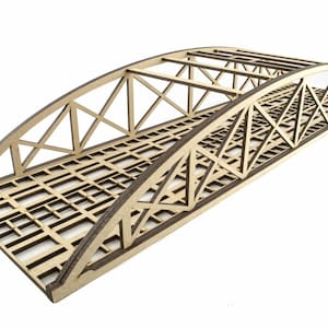 Peut inclure: Un pont modèle en bois avec un design en arc. Le pont présente un tablier en treillis et des structures de support complexes. La couleur naturelle du bois contraste avec les espaces ouverts, créant une structure miniature détaillée.