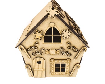 Può includere: Un ornamento per la casa di pan di zenzero in legno con dettagli a forma di bastoncino di zucchero, una porta a forma di cuore e una finestra con un design a bastoncino di zucchero. La casa è decorata con fiocchi di neve e volute.