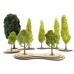 Peut inclure: Ensemble de modèles réduits d'arbres miniatures aux tons verts variés, avec des feuillages détaillés et des troncs texturés. Les arbres sont montés sur de petites bases en bois rondes et ovales. L'ensemble comprend diverses formes d'arbres, parfait pour les paysages miniatures.