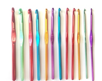 May include: A set of twelve multicolored aluminum crochet hooks arranged in a row. Each hook features a metallic finish in shades of red, green, blue, gold, and purple, with the specific size in millimeters clearly engraved on the handle of each tool.