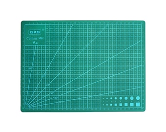 May include: A rectangular green A4 cutting mat by GKS featuring a white grid pattern, angle markings from 10 to 80 degrees, and a series of circular and square size guides. The mat includes printed measurements along the edges in centimeters.