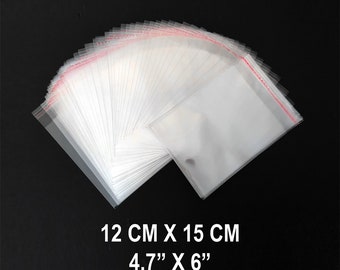 May include: A stack of clear, rectangular plastic bags with adhesive strips at the top, each measuring 4.7 inches by 6 inches. The bags are arranged in a fan shape, showcasing their transparent material and the red-printed adhesive seal line.