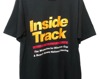 May include: Black t-shirt with a gold and red "Inside Track" logo. The text below the logo reads "The Magazine for Winston Cup & Busch Grand National Racing."