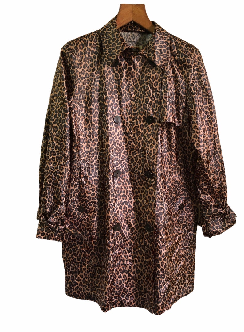 May include: A brown and black leopard print trench coat with a double breasted closure and a belt.