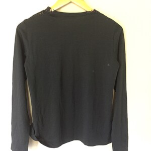 May include: Black long-sleeved shirt with a lace neckline.