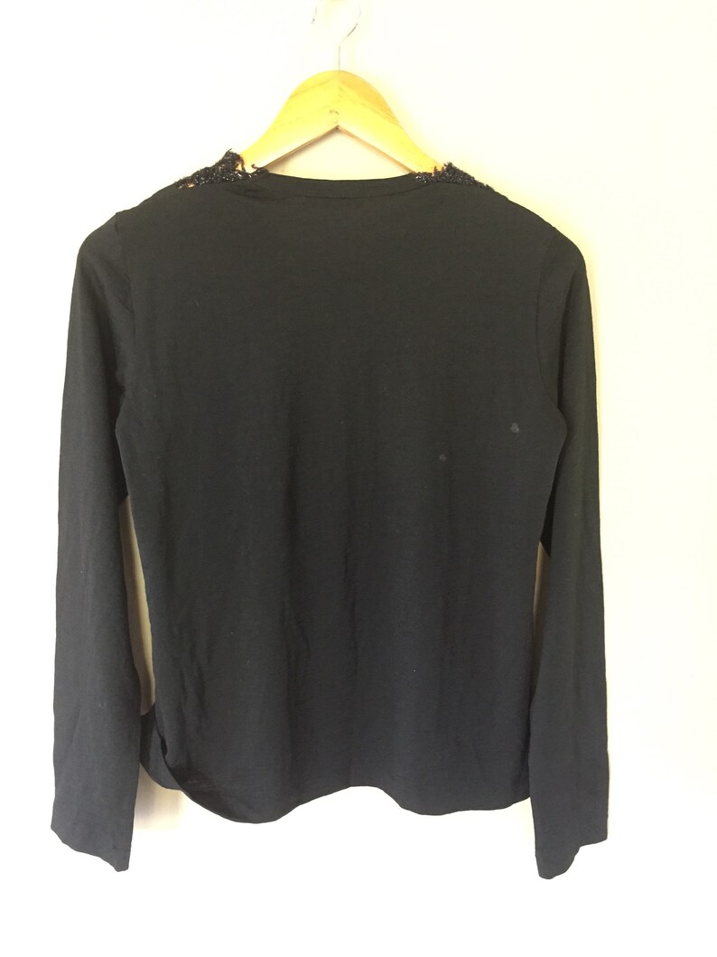 May include: Black long-sleeved shirt with a lace neckline.