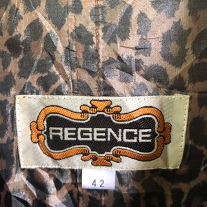 May include: A brown and black leopard print fabric with a white label that says "REGENCE" in a gold frame. The label also has a size tag that says "42".