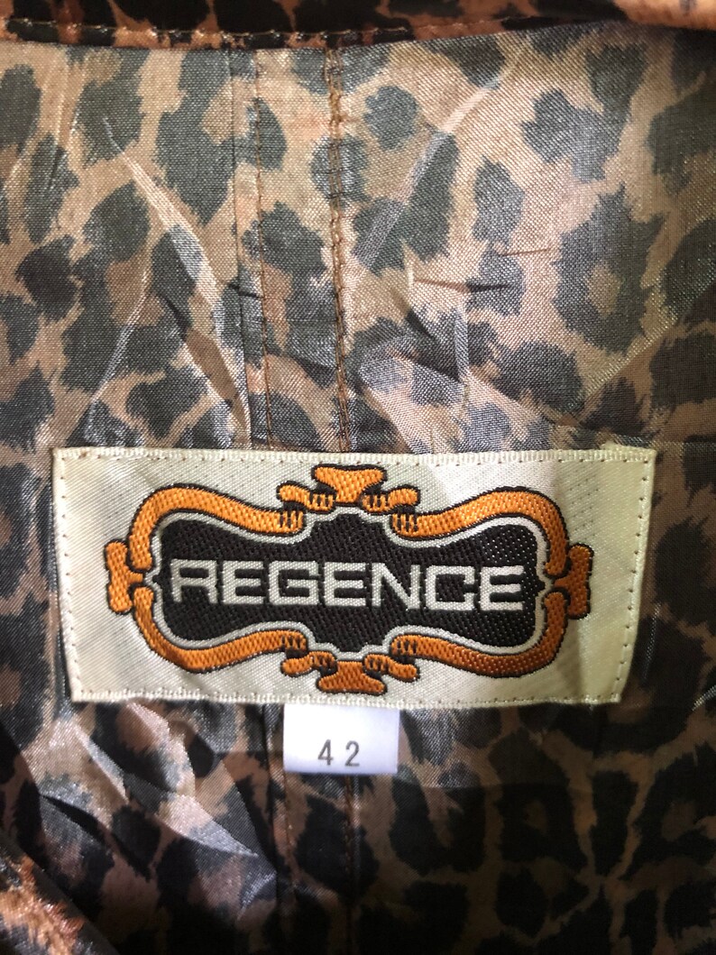 May include: A brown and black leopard print fabric with a white label that says "REGENCE" in a gold frame. The label also has a size tag that says "42".