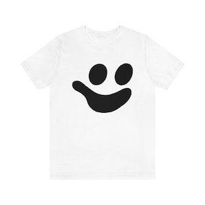 May include: White t-shirt with a black smiling face graphic.