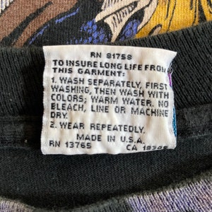 May include: White care tag with black text. The tag has instructions for washing and caring for a garment. The text reads: "RN 81758 To insure long life from this garment: 1. Wash separately, first washing, then wash with colors; warm water. No bleach, line or machine dry. 2. Wear repeatedly. Made in U.S.A. RN 13765 CA 1834"