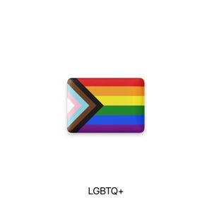 May include: A rectangular LGBTQ+ pride flag pin with a rainbow design and a chevron incorporating the transgender flag colors and brown and black stripes. The text "LGBTQ+" is below the pin.