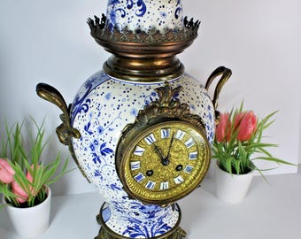 Relógio de parede antigo belga de cerâmica Boch com decoração de Delft, com cabeça de cariátide e pássaro.