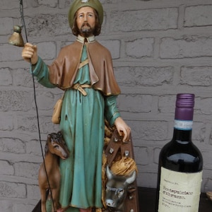 Puede incluir: Una taza de cerámica blanca con un asa negra y el texto "But First, Coffee" en negro, en negrita. La taza está sobre una superficie blanca.