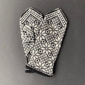 May include: A pair of black and white knitted mittens with a geometric pattern.