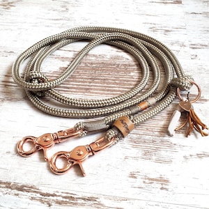 以下が含まれることがあります： 緑色のロープ製の犬用リードに、ローズゴールドのクリップが2つと、