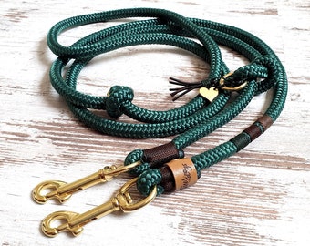May include: A green double-ended dog leash with two gold metal clips and a brown leather tag with the text "Two Dogs" on it.