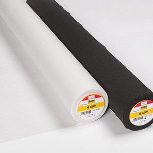 Könnte beinhalten: Zwei Stoffrollen, eine weiße und eine schwarze, mit Etiketten mit der Aufschrift "H 609".