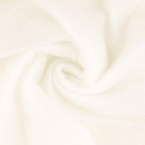 Op de afbeelding: Een close-up van een zachte, witte stof met een draaiende textuur. De stof is glad en lijkt van een lichtgewicht materiaal te zijn gemaakt.