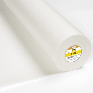 Pode incluir: Um rolo branco de entretela termocolante com um rótulo amarelo que diz "S 133".