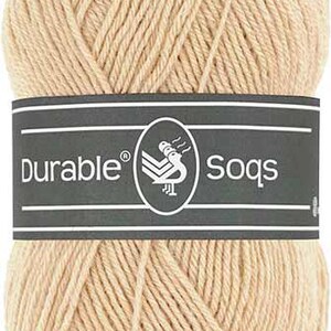 Peut inclure: Une pelote de fil beige avec une étiquette indiquant "Durable Socks".