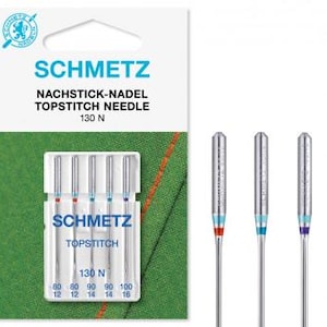 Könnte beinhalten: Eine Packung SCHMETZ Topstitch-Nadeln mit dem Text "SCHMETZ NACHSTICK-NADEL TOPSTITCH NEEDLE 130 N". Die Packung enthält Nadeln in den Größen 80, 90 und 100. Drei einzelne Nadeln sind ebenfalls abgebildet.